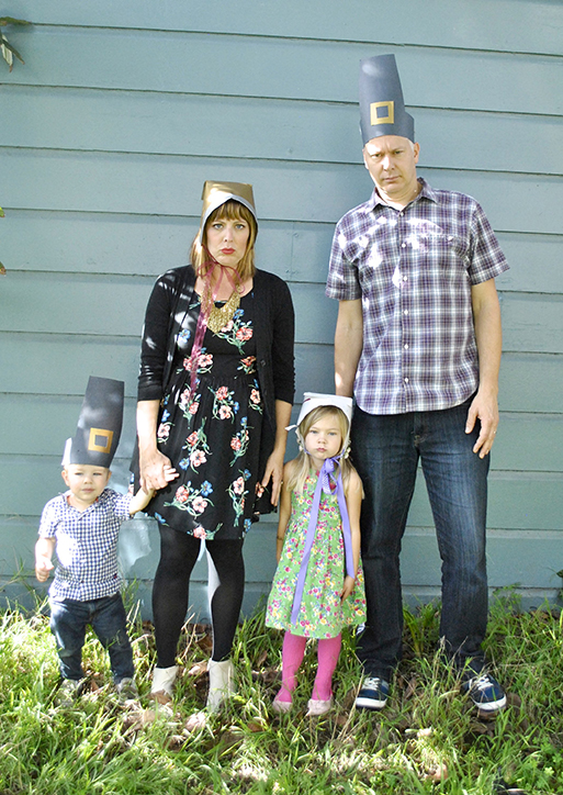 family in Thanksgiving hats being serious in backyard