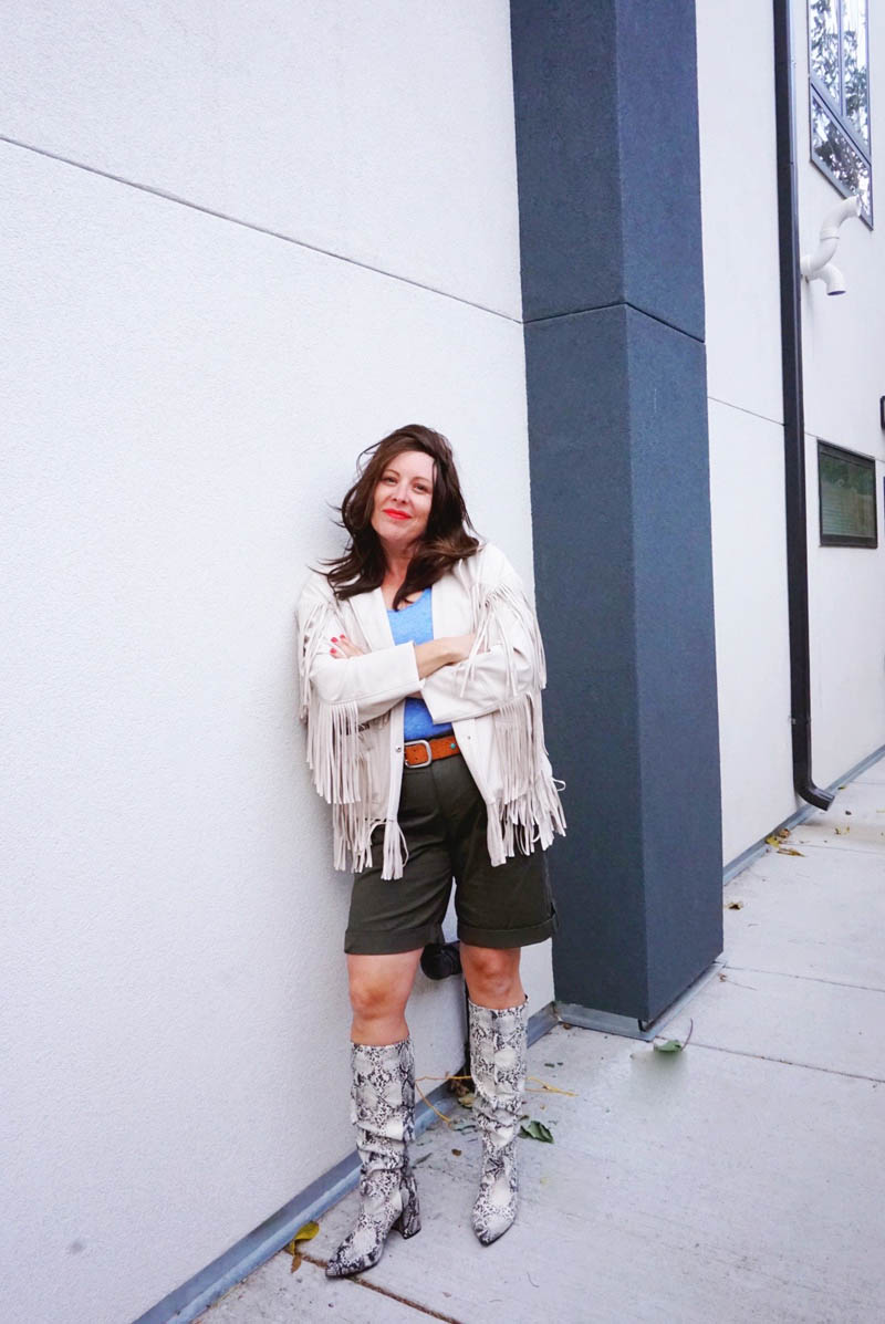 woman dressed as Sloane from Ferris Bueller's Day Off leaning against a wall